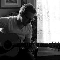 A Rare Serious Photo of Bennett Playing Guitar